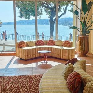 a living room with couches and a view of the water at Hôtel La Pérouse Nice Baie des Anges in Nice