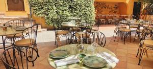 a restaurant with tables and chairs with plates on them at Hôtel La Pérouse Nice Baie des Anges in Nice