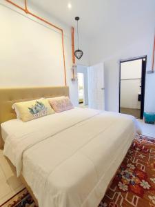 Tamu Beradu Seaview Private Villa 3 Bedroom في دونجون: سرير أبيض كبير في غرفة مع نافذة