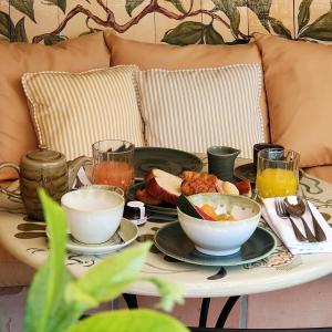 a table with plates of food and drinks on a couch at Hôtel La Pérouse Nice Baie des Anges in Nice