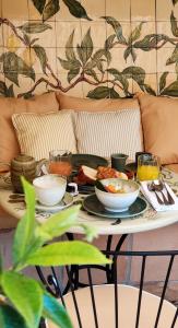 a table with plates of food on a couch at Hôtel La Pérouse Nice Baie des Anges in Nice