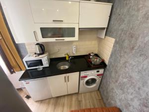 een kleine keuken met een wastafel en een wasmachine bij DVHOTEL in Istanbul