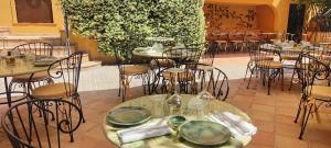 a restaurant with tables and chairs with plates on them at Hôtel La Pérouse Nice Baie des Anges in Nice
