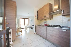 uma cozinha com armários de madeira e piso em azulejo em Il Terrazzo di Lucrezia - Goelba em Nisporto