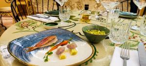a plate of fish and vegetables on a table at Hôtel La Pérouse Nice Baie des Anges in Nice