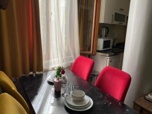 een eettafel met twee rode stoelen en een tafel met borden en kopjes bij DVHOTEL in Istanbul