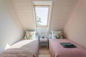 two beds in a small room with a window at Sjælegård Countryside Lodge in Allinge