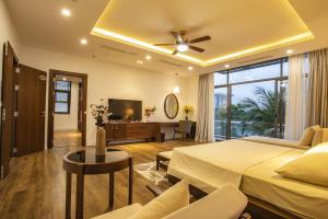 a hotel room with a bed and a living room at FLC Grand Villa BT33-04 in Sầm Sơn