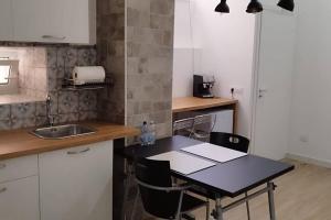 a kitchen with a sink and a table with chairs at Appartamento MI.6 in Naples