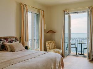 a bedroom with a bed and a view of the ocean at Hôtel La Pérouse Nice Baie des Anges in Nice