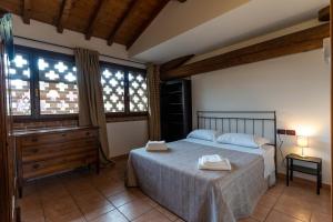 明乔河畔蓬蒂Agriturismo Corte Salandini的一间卧室配有一张床、梳妆台和窗户。