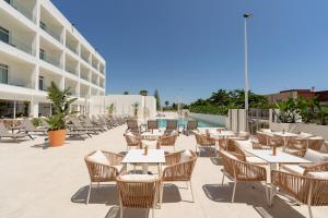 an outdoor patio with tables and chairs and a building at RH Silene Hotel & Spa 4 Sup in Castellón de la Plana