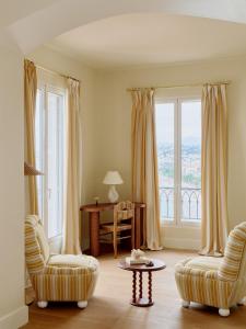 a living room with two chairs and a table at Hôtel La Pérouse Nice Baie des Anges in Nice