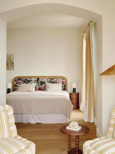 una camera bianca con un letto e due sedie di Hôtel La Pérouse Nice Baie des Anges - Recently fully renovated a Nizza