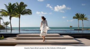 a woman standing on steps looking at the ocean at Jumeirah Al Qasr Dubai in Dubai