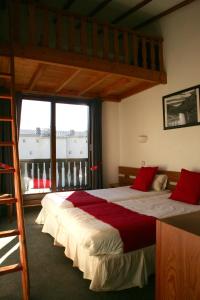 ein Schlafzimmer mit einem großen Bett und einem Loft in der Unterkunft Hôtel Valentin in Les Deux Alpes