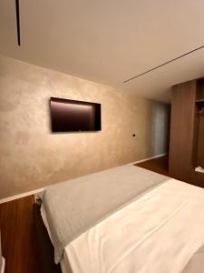 a bedroom with a bed and a tv on the wall at AGATE HOTEL self check in in Tirana