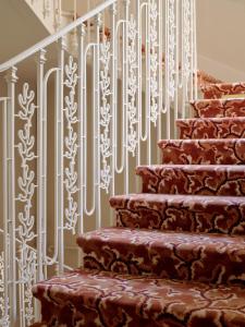 a stairway with a patterned stair railing with a stair tread at Hôtel La Pérouse Nice Baie des Anges in Nice