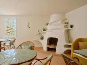 a living room with a fireplace and a table and chairs at Hôtel La Pérouse Nice Baie des Anges in Nice
