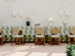 a living room with a couch with four chairs at Hôtel La Pérouse Nice Baie des Anges in Nice