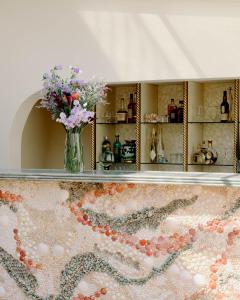 a vase of flowers sitting on a counter in a room at Hôtel La Pérouse Nice Baie des Anges in Nice