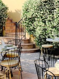 a group of tables and chairs in front of stairs at Hôtel La Pérouse Nice Baie des Anges in Nice