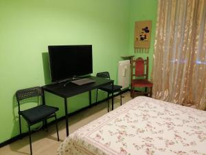 een slaapkamer met een bed en een bureau met een televisie bij Céline in Genua