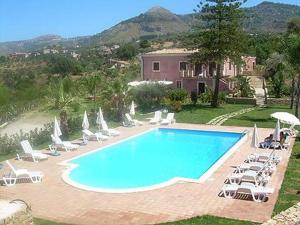 einen Pool mit Liegestühlen und ein Haus in der Unterkunft Agriturismo Villa Luca in SantʼAgata di Militello