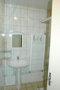 uma casa de banho branca com um lavatório e um chuveiro em Gite de l'ecole 