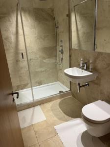e bagno con doccia, servizi igienici e lavandino. di Beautiful 2 bed Flat in Finchley Road, Camden a Londra
