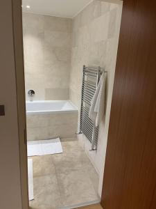 ein Badezimmer mit einer Badewanne und einem Waschbecken in der Unterkunft Beautiful 2 bed Flat in Finchley Road, Camden in London