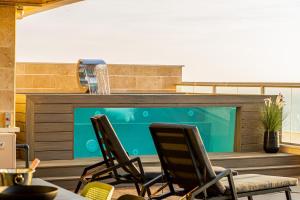 een patio met 2 stoelen en een zwembad bij Infinity Luxury Penthouse Ashkelon in Ashkelon