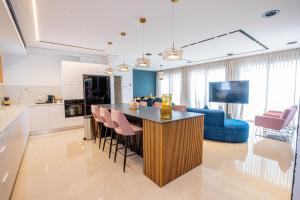 een keuken en een woonkamer met een bar en een bank bij Infinity Luxury Penthouse Ashkelon in Ashkelon