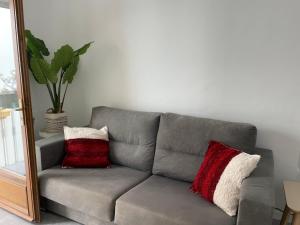 タリファにあるCasa Florinda Tarifaの赤と白の枕2つ付きのグレーのソファ