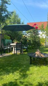 a picnic table with an umbrella next to a table with a picnic at Sweet Home Apartman in Balatonfüred