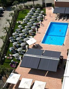 an overhead view of a pool with tables and umbrellas at The Sydney Hotel in Bologna