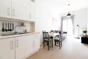 a kitchen with white cabinets and a table with chairs at Málaga Center Flat. Carmen City Center Roof-Terrace Boutique in Málaga