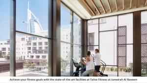 a group of people walking in a building with large windows at Jumeirah Al Naseem Dubai in Dubai