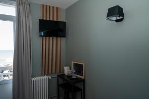 Ecke eines Zimmers mit einem TV an der Wand in der Unterkunft l'itinerance in Mers-les-Bains