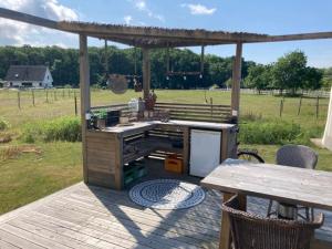 a grill on a deck with a table and a picnic table at Glamping i Döshult in Viken