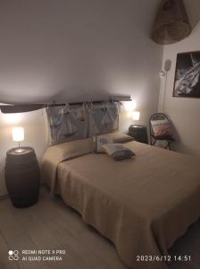 a bedroom with a large bed and two lamps at Appartamento Rocche Rosse in Acquacalda