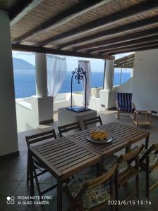 una mesa y sillas en un balcón con vistas al océano en Appartamento Rocche Rosse en Acquacalda