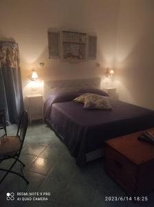 a bedroom with a bed and two lamps and a chair at Appartamento Rocche Rosse in Acquacalda