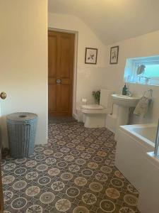 La salle de bains est pourvue d'un lavabo et de toilettes. dans l'établissement Beautiful Village Cottage 5 mins to Alton Towers, à Alton