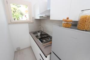 een kleine keuken met een fornuis en een raam bij Ville Pinetine in Bibione