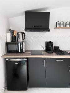 a desk with a microwave and a computer on it at Le gargantua, appartement à 500m du château in Chinon