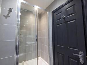 a bathroom with a shower and a black door at Pass the Keys High Specification Luxury City Centre Apartment in Birmingham