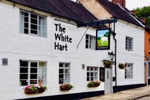 a white building with the white hat sign on it at Beautiful Village Cottage 5 mins to Alton Towers in Alton