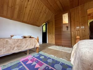 a bedroom with two beds and a rug at Guesthouse Freskia in Theth