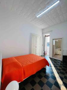 1 dormitorio con 1 cama roja en una habitación blanca en Palazzo Storico Mileto, en Mileto